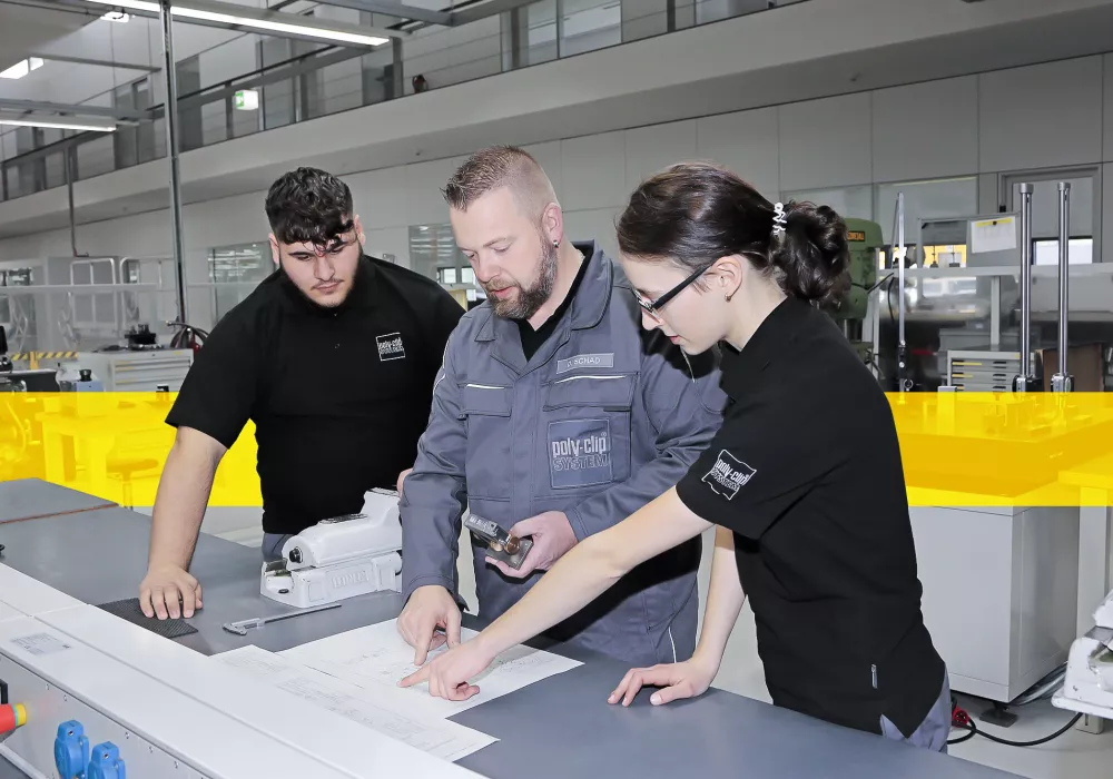 one worker and two trainees inside fabric hall